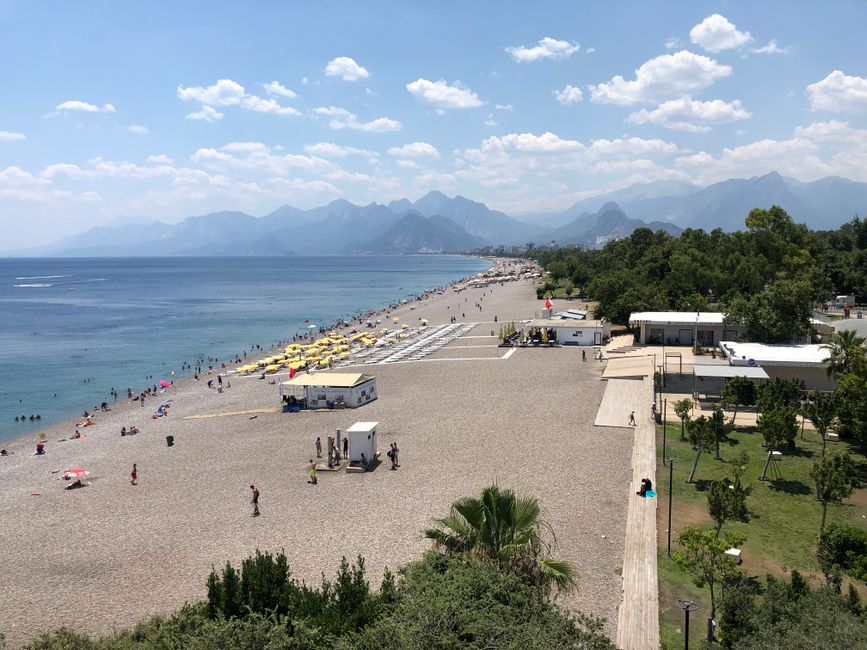 pebble beach with mountains in background