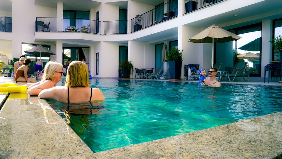 family relaxing by resort pool