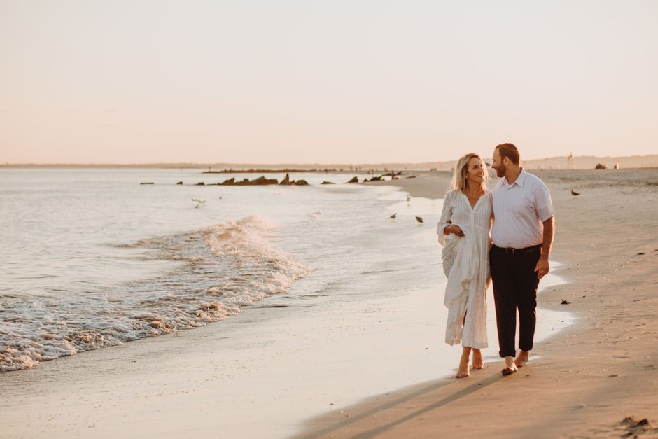 couple walking along a quiet beach at dusk